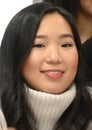 Headshot of a beautiful young Korean woman wearing a high necked sweater.