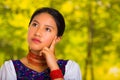 Headshot beautiful young woman wearing traditional andean blouse with red necklace, posing for camera touching face Royalty Free Stock Photo