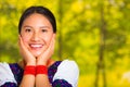 Headshot beautiful young woman wearing traditional andean blouse with red necklace, posing for camera touching face Royalty Free Stock Photo