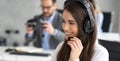 Headshot of beautiful young woman working in a call center. Friendly call center agent holding microphone while talking to Royalty Free Stock Photo