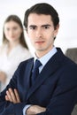 Headshot of businessman standing straight with colleagues at background in office. Group of business people discussing Royalty Free Stock Photo