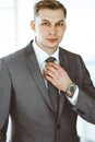 Headshot of businessman standing straight with colleagues at background in office. Group of business people discussing