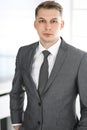 Headshot of businessman standing straight in office. Success and business workplace concept