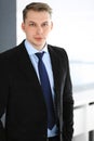 Headshot of businessman standing straight in office. Success and business workplace concept