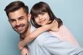 Happy young dad holding little preschool smiling daughter on back. Royalty Free Stock Photo