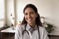 Headshot portrait of smiling female doctor in hospital