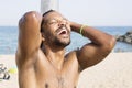 Portrait of cool young African man dancing at the beach on summer day. Royalty Free Stock Photo