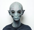 Headshot of an extraterrestrial creature with bluish skin wearing t-shirt against bright studio background in the style of ID or