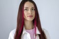 Headshot of a funny rebellious young woman with bright pink hair looking straight at the camera. Close-up of the girl