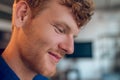 Headshot of a ginger young man looking down and smiling Royalty Free Stock Photo