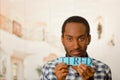 Headshot handsome man holding up small letters spelling the word tired and looking to camera Royalty Free Stock Photo