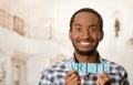 Headshot handsome man holding up small letters spelling the word write and smiling to camera Royalty Free Stock Photo