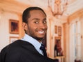 Headshot handsome man wearing business suit turning head and smiling to camera, lobby background Royalty Free Stock Photo