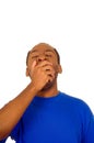 Headshot handsome man wearing strong blue colored t-shirt yawning and looking tired, white studio background