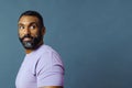 headshot of a handsome smiling african american man with beard and mustache purple shirt looking away Royalty Free Stock Photo