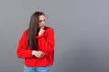Headshot of a happy emotional teenage girl with long hair dressed in a red sweater and jeans