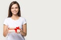Headshot of happy millennial woman presenting gift with copyspace background