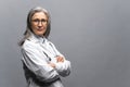 Headshot of intelligent professional mature female doctor with gray hair, wearing glasses, medical white gown and Royalty Free Stock Photo