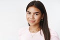 Headshot of kind and nice charming young indian female adolescent with long dark hair in pink t-shirt and earrings