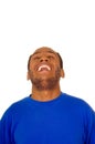 Headshot man wearing strong blue colored t-shirt laughing hard while tilting head backwards, white studio background