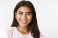 Headshot of nice sincere and gentle young teenage indian girl with earrings and neckles smiling broadly at camera