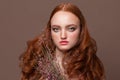 Headshot of a perfect redhead model. Redhead woman with curly ginger hairstyle holding flowers