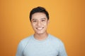 Headshot photo of Asian man with smiling face on orange background Royalty Free Stock Photo