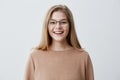 Headshot of pleasant-looking young Caucasian woman wearing eyeglasses with broad smile showing her straight white teeth Royalty Free Stock Photo