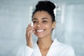 African woman cleanses face holding super gentle facial sponge