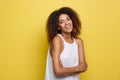 Headshot portrait of beautiful attractive African American woman posting crossed arms with happy smiling. Yellow studio Royalty Free Stock Photo