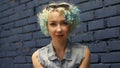 Headshot Portrait of beautiful blue haired girl with curly hair looking at camera.