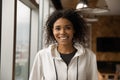 Headshot portrait of beautiful smiling millennial afro american female indoors