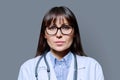 Headshot portrait serious female doctor looking at camera on gray background Royalty Free Stock Photo