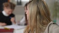 Headshot portrait of exhausted tired beautiful woman shaking head sighing with blurred schoolgirls misbehaving at