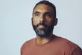 headshot portrait of a handsome thoughtful bearded mid man looking away at copy space against gray background Royalty Free Stock Photo