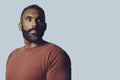 headshot portrait of a handsome thoughtful bearded mid man looking at copy space against gray background