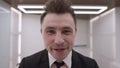 Headshot portrait of happy Caucasian businessman loosing necktie smiling looking at camera. Close-up face of confident