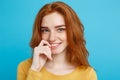 Headshot Portrait of happy ginger red hair girl with freckles smiling looking at camera. Pastel blue background. Copy Royalty Free Stock Photo