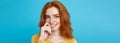 Headshot Portrait of happy ginger red hair girl with freckles smiling looking at camera. Pastel blue background. Copy Royalty Free Stock Photo