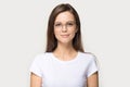 Headshot portrait of millennial girl in glasses posing in studio