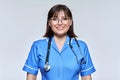 Headshot portrait of nurse in blue uniform looking at camera on light studio background Royalty Free Stock Photo