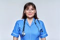 Headshot portrait of nurse in blue uniform looking at camera on light studio background Royalty Free Stock Photo