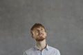 Red-haired young hipster man looking up with dreaming expression on face Royalty Free Stock Photo