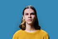 Headshot portrait of serious teenage guy on blue studio background Royalty Free Stock Photo