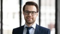 Headshot portrait of smiling businessman in glasses at workplace