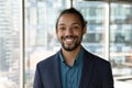 Headshot portrait of smiling ethnic businessman in office