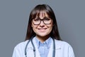 Headshot portrait smiling female doctor looking at camera on gray background Royalty Free Stock Photo