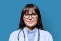 Headshot portrait smiling female doctor looking at camera on blue background Royalty Free Stock Photo