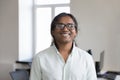 Headshot portrait smiling Indian businessman posing at workplace