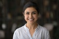 Headshot portrait of smiling Indian millennial woman